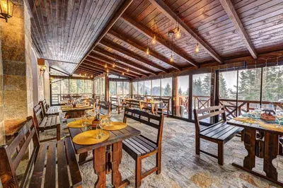 a dining room with tables and chairs and windows at N.Joy Holiday Apartment 534 by Oak Residence in Smolyan