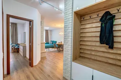 a hallway with a brick wall and a staircase with a coat hanging at N.Joy Holiday Apartment 532 by Oak Residence in Smolyan