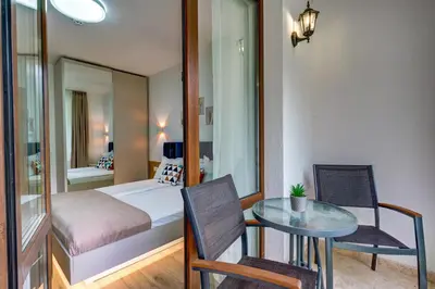 a small room with a bed and a table and a bedroom at N.Joy Holiday Apartment 532 by Oak Residence in Smolyan