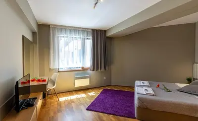 a bedroom with a bed and a purple rug at N.Joy Holiday Apartment 413 by Sunny Hills in Pamporovo
