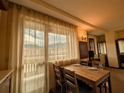 a dining room with a table and a large window at Great View Apartment near Gondola in Bansko