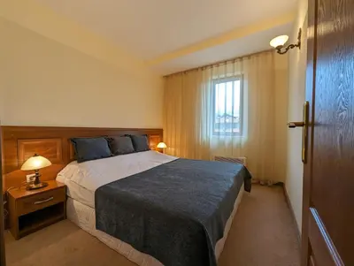 a bedroom with a large bed and a window at Great View Apartment near Gondola in Bansko