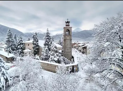 a building with a bell tower covered in snow at Ski view suite Emerald Bansko in Bansko