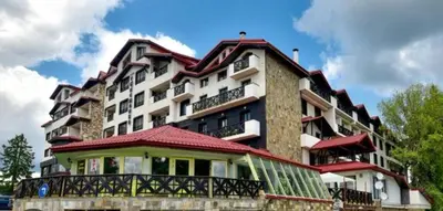 a large building with a balcony in front of it at Private Apartments in Hotel Snezhanka in Pamporovo