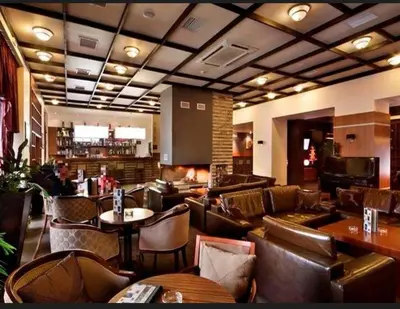 a restaurant with chairs and tables and a bar at Private Apartments in Hotel Snezhanka in Pamporovo