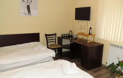 a bedroom with a desk and a bed and a desk with a computer at Deers in Bansko