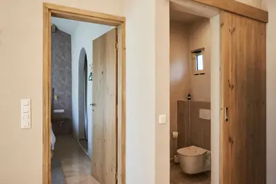 a bathroom with a toilet and a door to a hallway at Villa Alma 1910 Starosel in Starosel