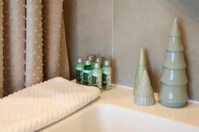 a white sink with bottles of toothpaste and a mirror at Villa Alma 1910 Starosel in Starosel