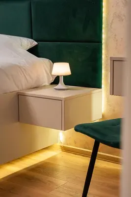 a bed with a green headboard and a table with a lamp at One-Bedroom apartment with Free Street Parking, Free Gym Pass and Office Setup in Plovdiv
