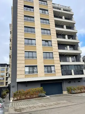 a tall building with a parking lot in front of it at Harmony apartment in Sofia