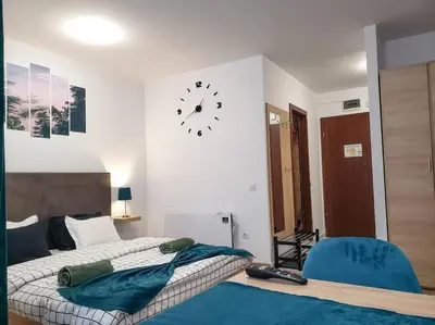 a bedroom with two beds and a clock on the wall at Forest View Studio D25 in Borovets