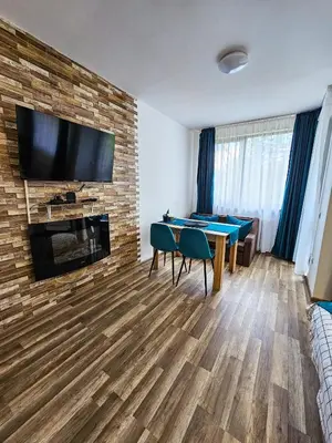 a living room with a table and a tv on a brick wall at Forest View Studio D25 in Borovets