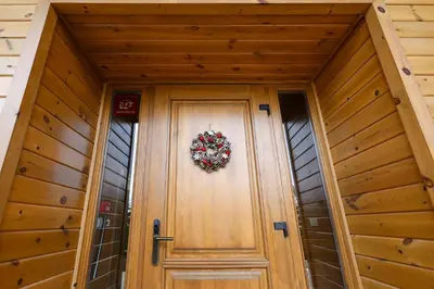 a wooden door with a wreath on it at Villa Katerina Deluxe w Sauna - Pirin Golf and Country Club in Bansko