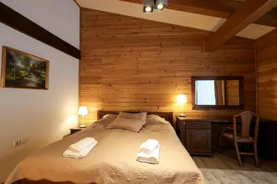 a bedroom with a bed and a desk and a chair at Villa Katerina Deluxe w Sauna - Pirin Golf and Country Club in Bansko