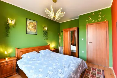 a bedroom with green walls and a large bed at Cedar Lodge III One BDRM Flat B2 in Bansko
