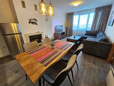 a living room with a table and a couch at VIVA 4-A-16 ski to the door Grand Monastery in Pamporovo