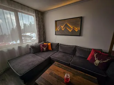 a living room with a couch and a table at VIVA 4-A-16 ski to the door Grand Monastery in Pamporovo