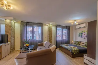 a bedroom with a bed and a couch and a table at Cozy & Delightful Apart & AUBG & Free Garage Parking in Blagoevgrad