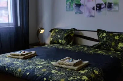 two towels on a bed with a blue comforter at Cozy & Delightful Apart & AUBG & Free Garage Parking in Blagoevgrad