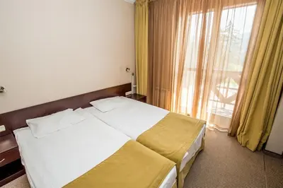 a bedroom with a large bed and a window at Apartments Hotel Snejanka Pamporovo in Pamporovo