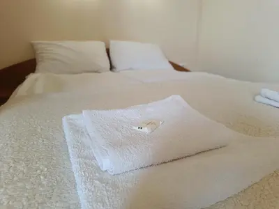 a white towel is sitting on a bed at Ski holiday in Lucky Pamporovo in Pamporovo