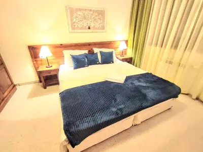 a bedroom with a large bed with blue pillows at Private 1bedroom apt in SPA Resort - SPA included in Bansko