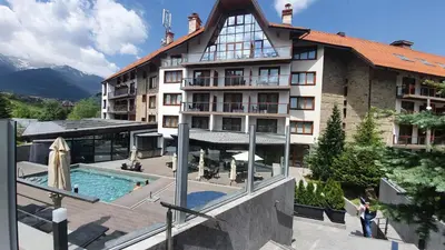 a large building with a swimming pool in front of it at Private 1bedroom apt in SPA Resort - SPA included in Bansko