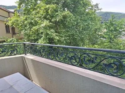 a railing on a balcony with a view of trees at Danaya in Petrich