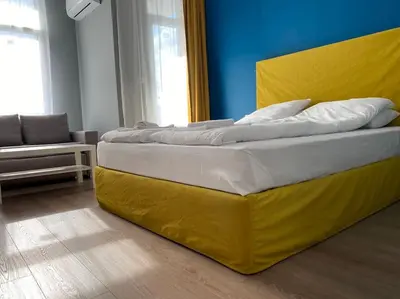 a large bed with a yellow headboard in a room at Boutique Magenta Pearl Apartment with free WiFi in Sofia