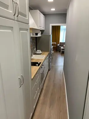 a kitchen with white cabinets and a wooden floor at Boutique Magenta Pearl Apartment with free WiFi in Sofia