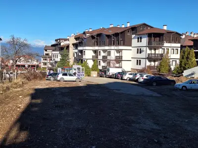 a parking lot with cars parked in front of a building at Top location ski-in ski-out and Swimming Pool in Bansko