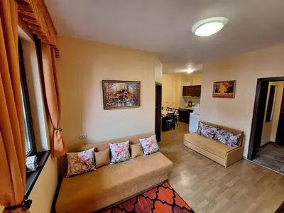 a living room with a couch and a kitchen at Top location ski-in ski-out and Swimming Pool in Bansko