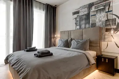 a bedroom with a large bed with two towels on it at Amuse Bouche by Skabrin in Bansko