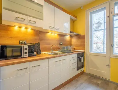 a kitchen with white cabinets and a sink and a microwave at Golden Glow Residence in Sofia