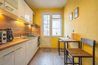 a kitchen with yellow walls and a table and a sink at Golden Glow Residence in Sofia