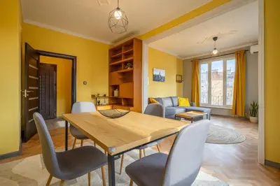a living room with a wooden table and chairs at Golden Glow Residence in Sofia