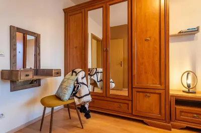 a room with a wooden cabinet and a chair at Premium comfy 2BDR Apt - Free Parking - Fast Wi-Fi in Sofia