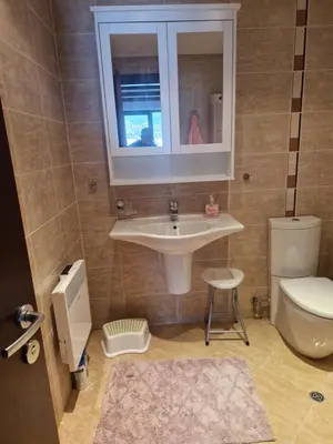 a bathroom with a sink and a toilet and a window at Terra SP apartments-Razlog in Razlog