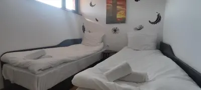 a room with two beds and a chair in it at Royal Park SP apartments-Bansko in Bansko