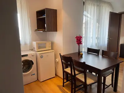 a kitchen with a dining room table and a microwave at Royal Park SP apartments-Bansko in Bansko