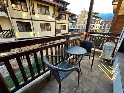a balcony with two chairs and a table at Great apartments in Downtown in Bansko