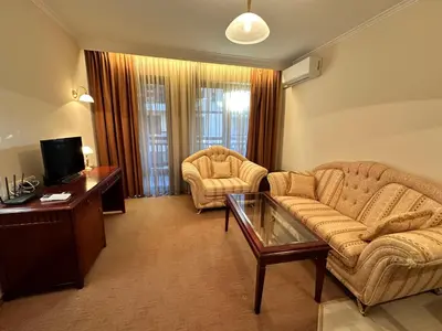 a living room with a couch and two chairs and a tv at Great apartments in Downtown in Bansko
