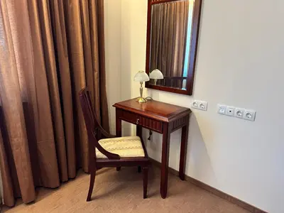 a wooden desk with a chair and a mirror at Great apartments in Downtown in Bansko