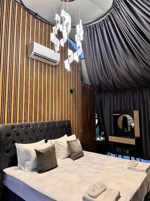 a bedroom with a large bed with a black curtain at Glass Domes - by The Wind Mills Hydropark in Gorna Malina