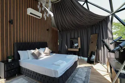 a bedroom with a bed in a tent at Glass Domes - by The Wind Mills Hydropark in Gorna Malina