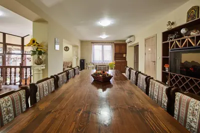 a dining room with a long wooden table and chairs at Guest House Mira in Sapareva Banya