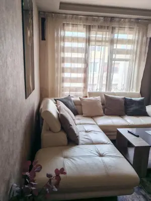 a living room with a white couch in front of a window at Heart of Pernik apartment in Pernik