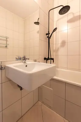 a white bathroom with a sink and a tub at Cedar Lodge III 2 BDRM Flat B12 in Bansko