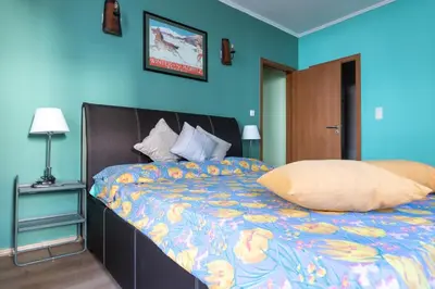 a bedroom with a large bed with a blue wall at Cedar Lodge III 2 BDRM Flat B12 in Bansko
