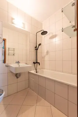 a white bathroom with a tub and a sink at Cedar Lodge III 2 BDRM Flat B12 in Bansko